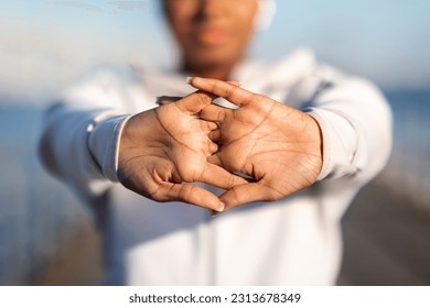 Closeup Shot Of Young Black Female Stretching Fingers Before Sport Training Outdoors, Unrecognizable African American Woman Warming Up Arm Muscles While Working Out On Pier Near Sea, Cropped