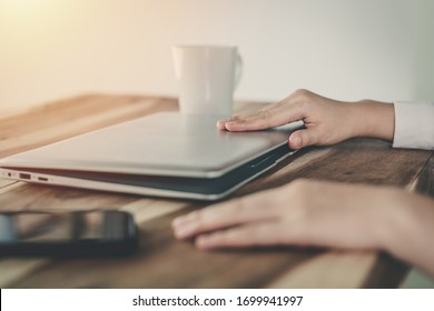 Close-up Shot Of A Young Business Woman Shutting Down Her Laptop After Work.