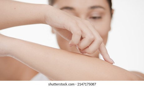 Close-up shot of young Caucasian plus size woman who touches her smooth forearm against white background | Smooth skin and beauty care concept - Shutterstock ID 2147175087
