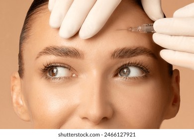 Closeup shot of young Caucasian woman getting beauty cosmetic injection in forehead, beautiful lady getting anti-aging treatment - Powered by Shutterstock