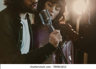 close-up shot of young couple performing song with vintage microphone - Powered by Shutterstock