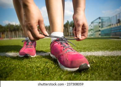 Closeup Shot Of Young Woman Tying Shoe Laces Before Running