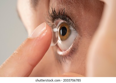 Close-up shot of young woman wearing contact lens. - Shutterstock ID 2033706785