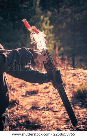 Closeup of Shotgun Shells Ejection After a Shot with Smoke Coming Out of the Barrel. Autumn Forest in the Background. Shooting and Hunting Theme.