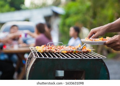 Close-up shots of a man doing a barbecue to celebrate with friends in the evening.