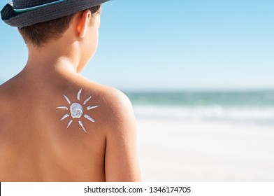 Closeup Of Shoulder Boy With Sun Design Made With Sunscreen. Back View Of Young Boy With Sun Painted By Sunblock Cream On His Shoulder. Cute Child With Suntan Lotion On His Back At The Beach.