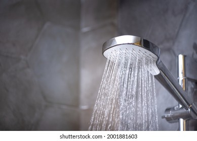 Closeup Of Shower Head With Running Water In The Bathroom. Cold Water Therapy. 