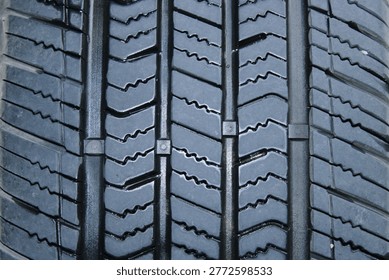 A close-up shows the tread patterns on a black tire. The grooves vary in shape and depth, designed for grip and traction. This image highlights the importance of tire design.