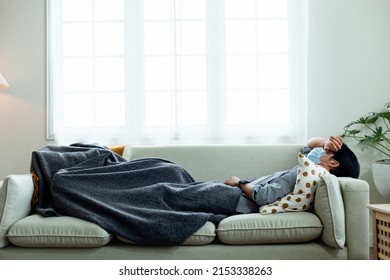 Close-up Of A Sick Asian Man Because Of The Coronavirus, Covid-19, Sleeping On The Sofa In The House. Quarantine. Crows To Heal From Sickness From The Virus. Illness, Health Care