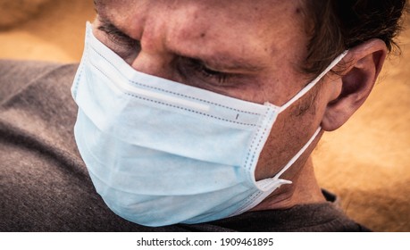 Close-up Side Portrait Man Wear Protect Mask, Face Expression Emotion, Furrowed Brow Wrinkle, Look Down. COVID Stress Syndrome, Mental Health, Fear Of Danger Contamination, Adverse Social Consequence