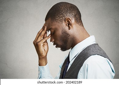 Closeup side profile portrait, headshot sad depressed, alone, disappointed gloomy young man resting his head on hand having suicidal thoughts isolated black background. Human emotion facial expression