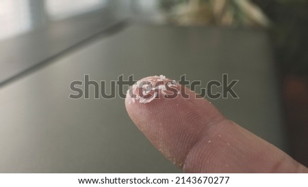 Close-up side shot of microplastics on human fingers. Concept for water pollution and global warming. Climate change idea. Soft focus on a bunch of micro plastic that cannot be recycled.