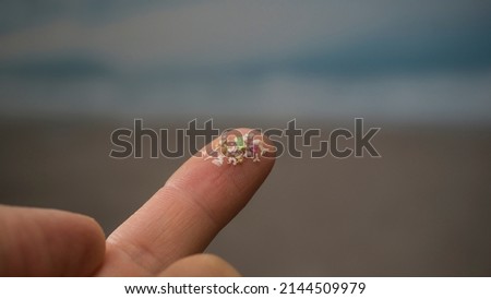 Close-up side shot of microplastics on human fingers. The concept for water pollution and global warming. Climate change idea. Soft focus on a bunch of micro plastic that cannot be recycled.