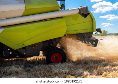 Closeup Side View Big Powerful Industrial Combine Harvester Machine Reaping Golden Ripe Wheat Cereal Field And Grinding Straw On Bright Summer Day. Agricultural Field Machinery Landscape Background