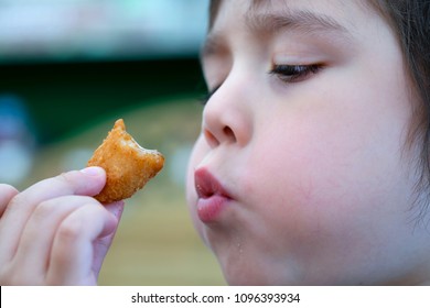 Closeup Side View Of Cute Little Boy Blowing Hot Scampi On His Hand, Selective Focus Of Child Eating Scampi, Head Shot Of Kid Cooling Down His Food