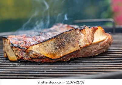 Close-up Side view of a grilled beef rib on a barbecue grill
