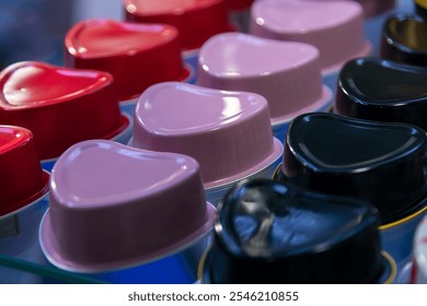 Close-up side view of group of various empty heart shaped metal food preserve packages. Soft focus. Copy space. Container background theme.