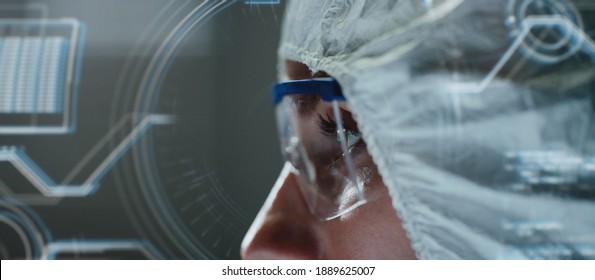 Close-up Side View Of Lab Tech Wearing Safety Goggles And Overalls Covering Her Head. Concept Of Scientists Seeking To Create Efficient Anti-coronavirus Treatment. Incorporated Graphic Interface