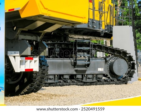 Close-up side view of a large-class excavator undercarriage, showcasing detailed final drive, sprocket, bottom roller, top roller, track shoe, track link, and operator ladder.