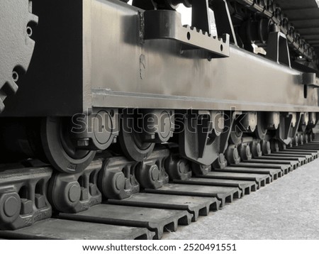 Close-up side view of a medium-class excavator undercarriage, showcasing detailed final drive, sprocket, bottom roller, top roller, track shoe, track link, and operator footstep.