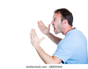 Closeup side view profile portrait of angry upset young man, worker, employee, business man hands in air, open mouth yelling isolated on white background. Negative emotions, facial expression reaction