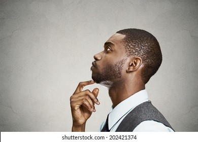 Closeup Side View Profile Portrait, Headshot Young Man Daydreaming Deeply About Something With Chin On Hand Looking Upwards, Isolated Black Background Space To Left. Emotion Facial Expressions Feeling