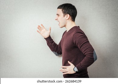 Closeup, Side View Profile Portrait Angry Man With Hands In Air, Wide Open Mouth Yelling, Isolated Gray Background. Negative Emotion, Facial Expression Feelings. Conflict Scandal Problems