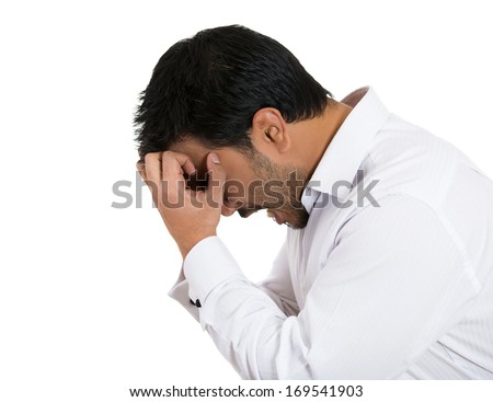 Closeup side view profile portrait of sad bothered stressed young man covering face with hands really depressed about something, isolated white background. Negative emotion facial expression feeling