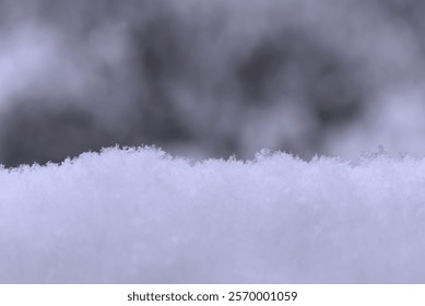 A close-up side view of a stack of clean snow with a blurry background.