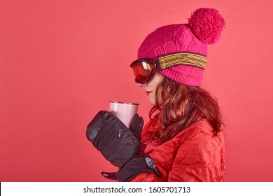 Closeup Side View Studio Shot Portrait Woman Wearing Rad Ski Clothes And Standing In Red Background With Tinsel And Ski Mask