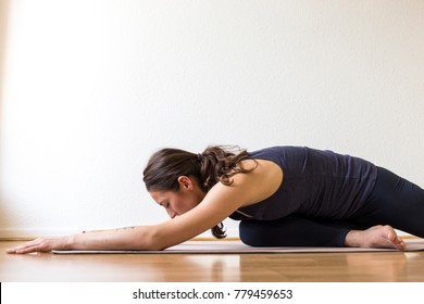 Close-up Side View Of A Young Woman Working Out At Home, Doing The Sleeping Swan Yin Yoga Posture, Medium Length.