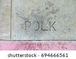 Closeup of sidewalk with Polk street name written on it