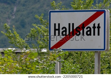 Closeup sign with bushes and mountains background end crossed out wold famous town Hallstatt upper Austria Salzkammergut