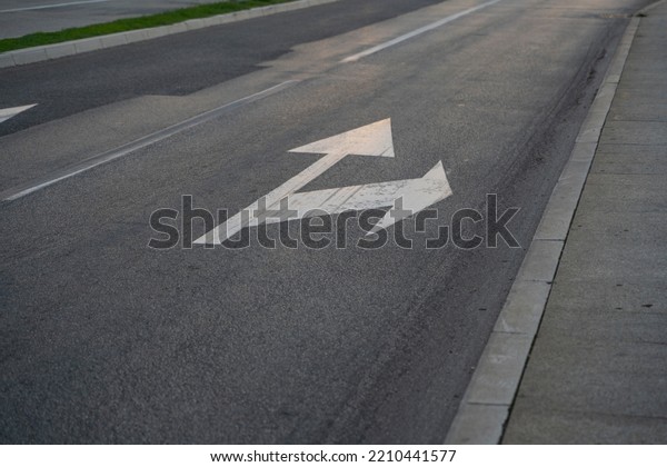 a close-up of a sign drawn on the road signifying\
a right turn or straight ahead. Tools for regulating traffic rules.\
Road signs.