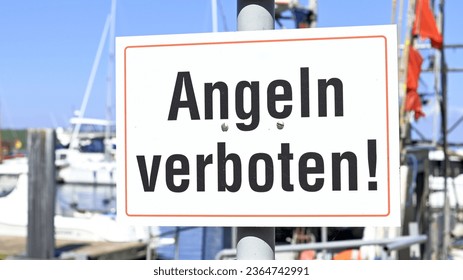 Close-up of a sign in the sunshine in a harbor on No Fishing! is written in German script - Shutterstock ID 2364742991