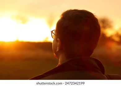 Close-up silhouette of man looking at sunrise. Mental health, hope, happiness concept. Dream autumn. Open mind, new goals and decisions. Man embracing hope in the sunlight.  - Powered by Shutterstock