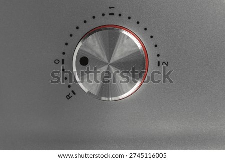 Close-Up of Silver Control Dial with Red Accent on Modern Kitchen Appliance