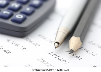 Close-up of silver pen, black pensil and calculator on paper table numers. - Shutterstock ID 52884196