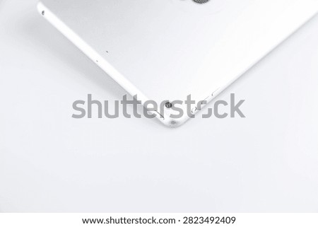 Close-up of a silver tablet on a white background, showing the back camera and sleek minimalist design with ample copy space.