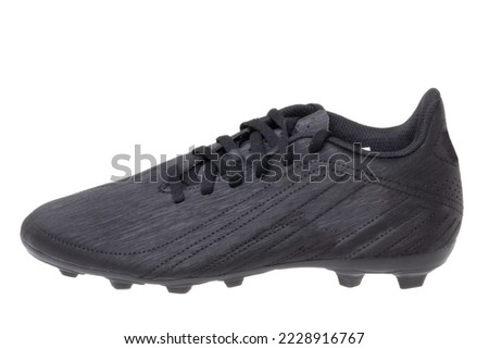 Closeup of a single black leather football boot isolated on white background. Professional athletics boys outdoor training shoes. Sports shoes.