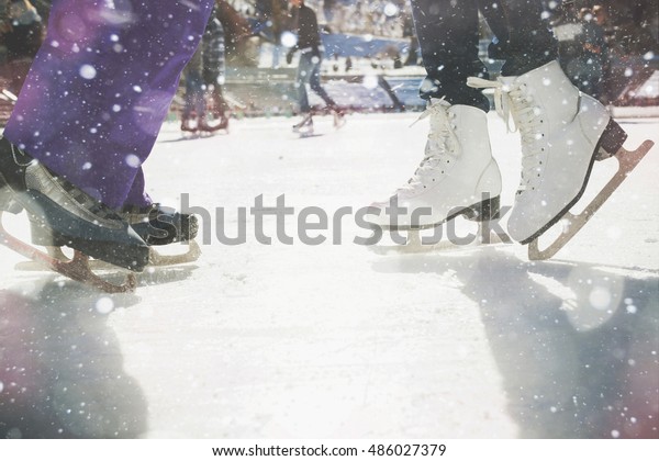 Closeup skating shoes ice\
skating outdoor at ice rink. Magical glitter of snowy snowflakes\
and bokeh. Healthy lifestyle and winter sport concept at sports\
stadium.