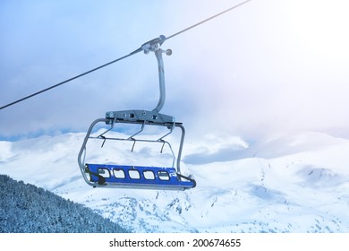 Close-up Of Ski Lift Chair With Mountain Tops On The Background.