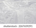 Close-up of a ski track or ski trail in the snow on a cold winter day. Skiing is a good outside winter activity and exercise practice. 