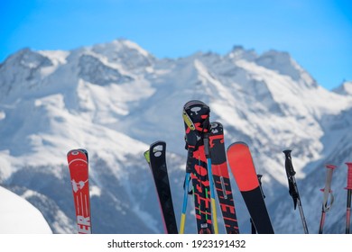 close-up of skies against a background of snow-capped mountains