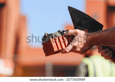 Close-up of Skilled worker bricklayer hands laying bricks on a construction site