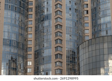 A close-up of a skyscraper with windows and reflections in it