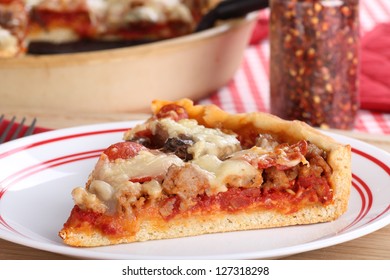 Closeup Of A Slice Of Deep Dish Sausage And Pepperoni Pizza On A Plate