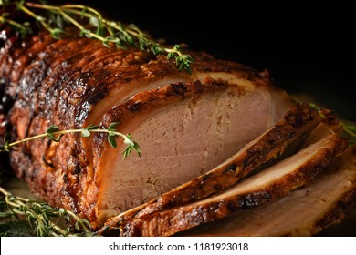 Close-up of sliced roast pork with thyme herb garnish, ready to serve. the perfect image for your bistro or restaurant cover art with copy space. - Powered by Shutterstock