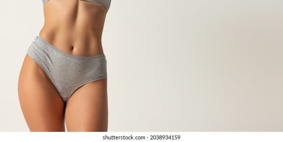 Close-up Slim Female Body In Gray Inner Wear Isolated On Grey Background. Concept Of Beauty, Body And Skin Care, Health, Plastic Surgery, Fashion, Cosmetics, Spa. Copy Space For Ad.