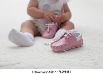 Close-up Small Child Dresses His First Shoes, Soft And Comfortable Leather Shoes. Little Baby Wear Shoes.                              